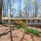 a front view of house with yard and trees around