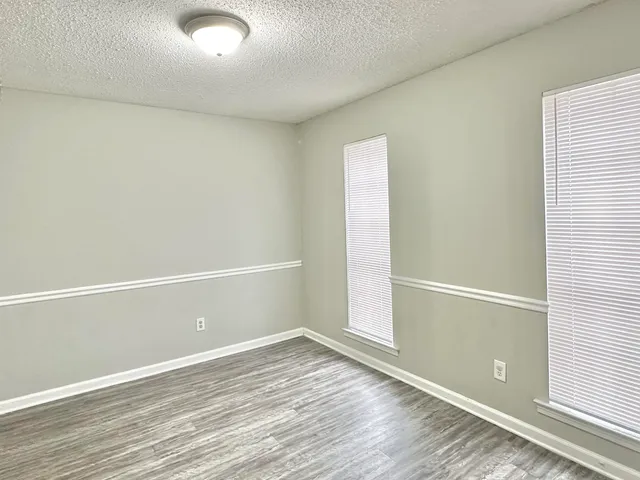 an empty room with wooden floor and window