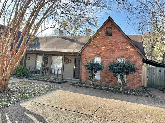 a view of a large house with a tree in front