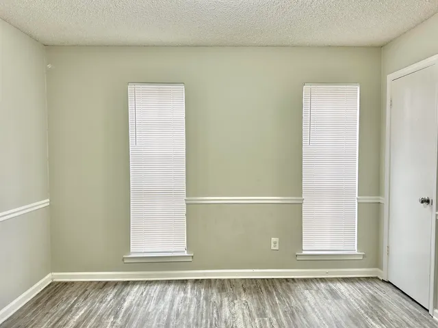 a view of a small space with wooden floor and a window