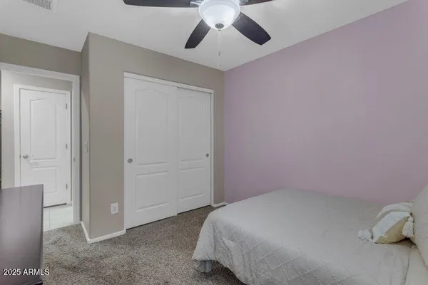 a bedroom with a bed and a ceiling fan
