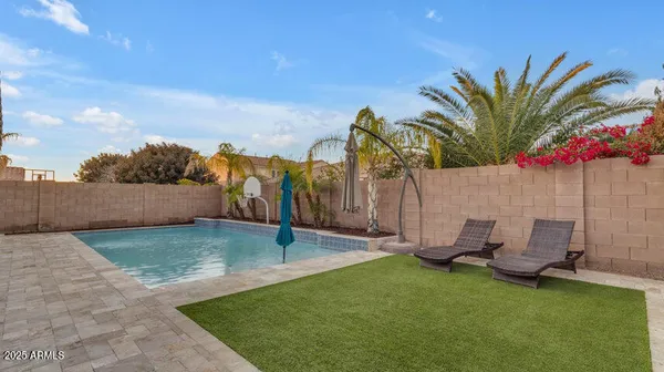 a view of a backyard with lawn chairs