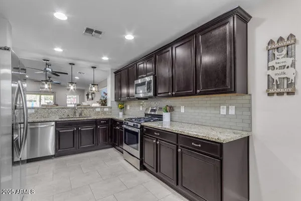 a kitchen with stainless steel appliances granite countertop stove top oven microwave and refrigerator