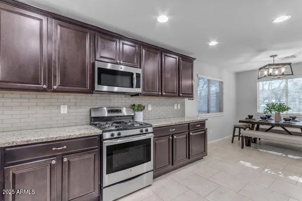 a kitchen with granite countertop wooden cabinets stainless steel appliances and a window