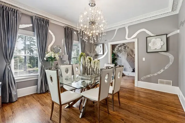 a view of a dining room with furniture a chandelier and wooden floor