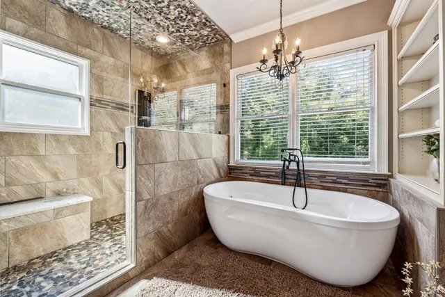 a white bath tub sitting in a bathroom next to a window