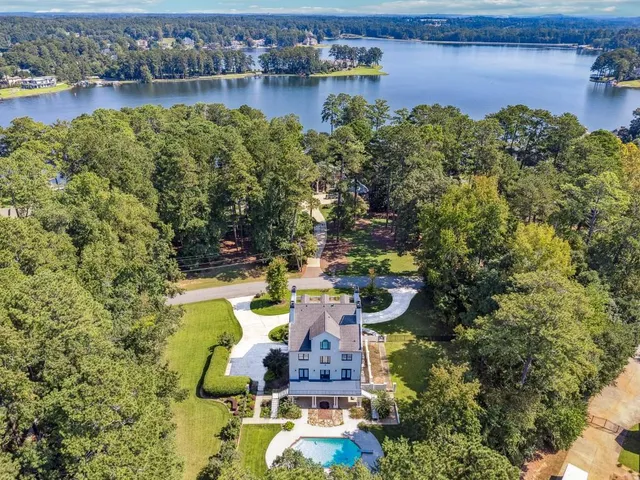 an aerial view of a house with swimming pool and lake view