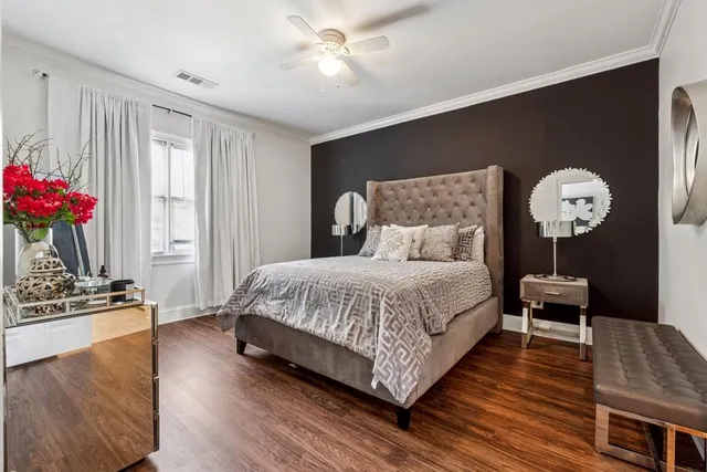 a spacious bedroom with a bed and wooden floor