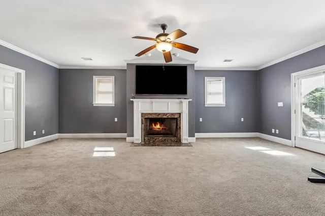a view of an empty room with window and fireplace