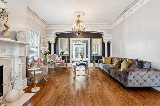 a living room with fireplace furniture and a chandelier