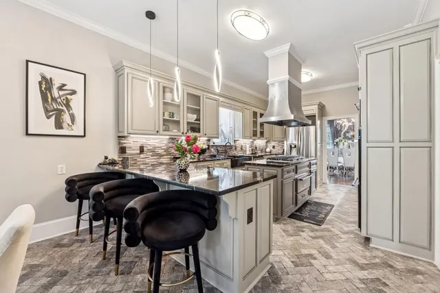 a kitchen with stainless steel appliances kitchen island granite countertop a sink and a refrigerator