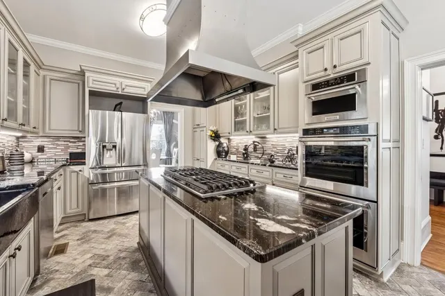 a kitchen with granite countertop stainless steel appliances and a stove top oven