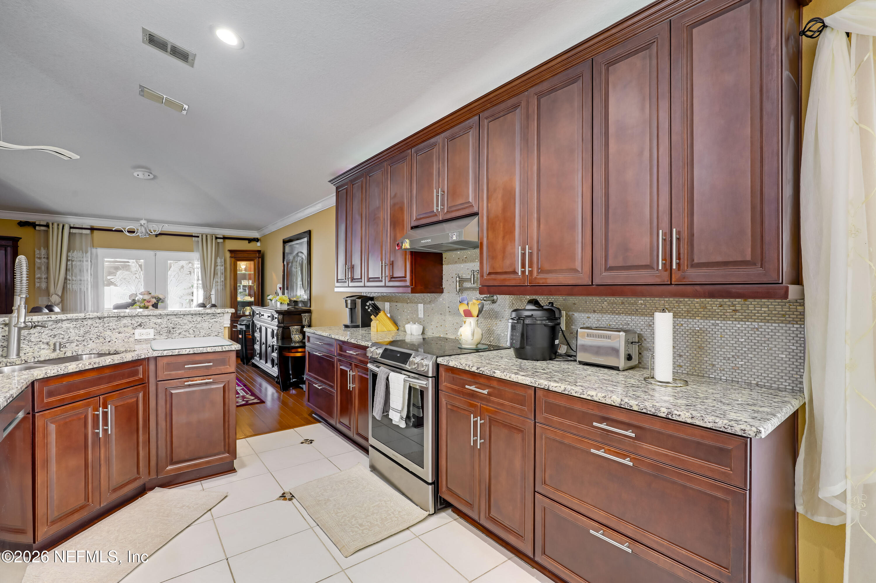 12559 Reeding Ridge Drive North Jacksonville, FL 32225 - Photo 22 of 42 a kitchen with granite countertop wooden cabinets stainless steel appliances a sink and a window