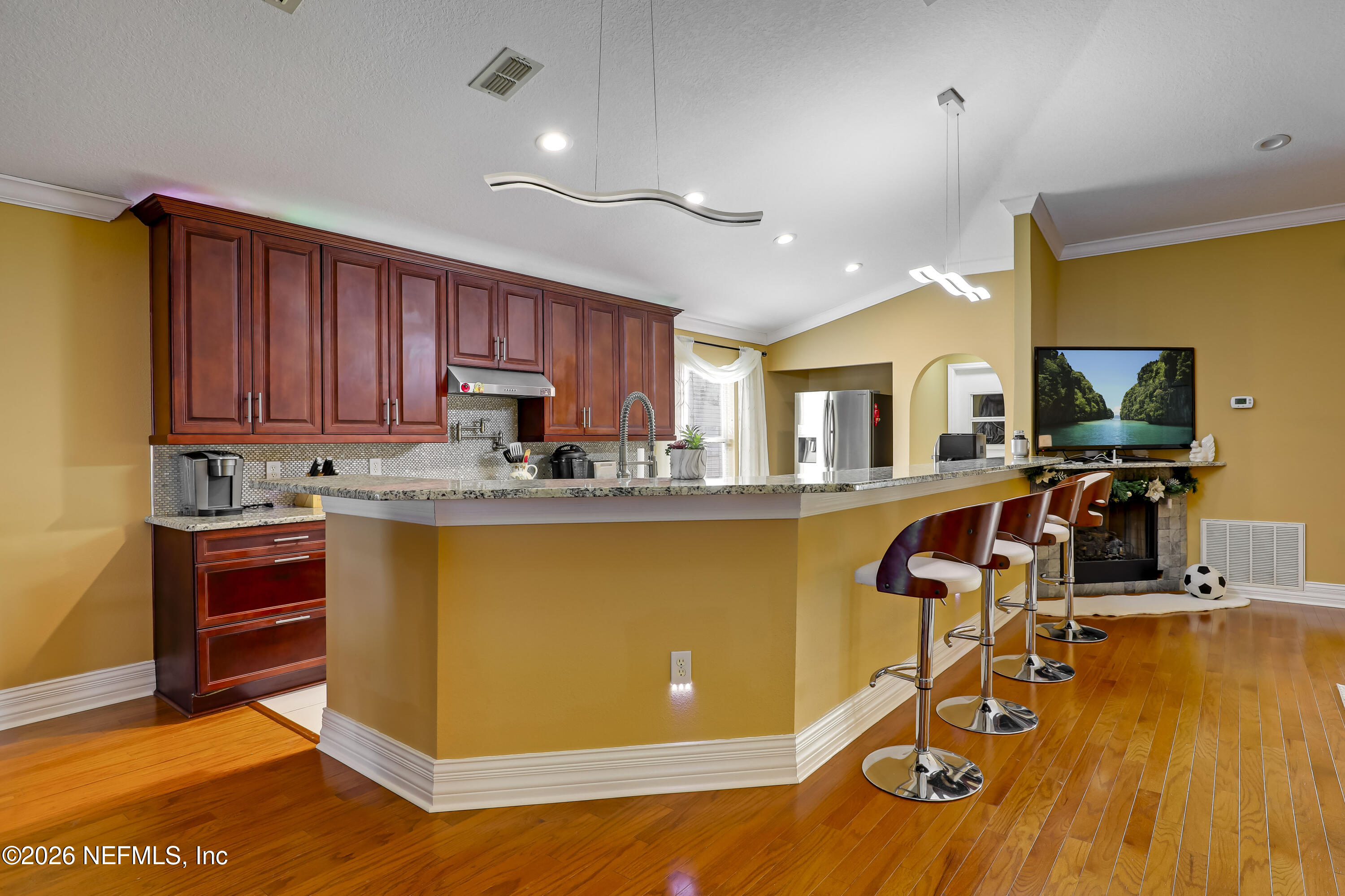 12559 Reeding Ridge Drive North Jacksonville, FL 32225 - Photo 4 of 42 a living room with stainless steel appliances granite countertop a refrigerator a stove top oven a dining table and chairs with wooden floor