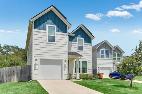 a front view of a house with a yard and trees