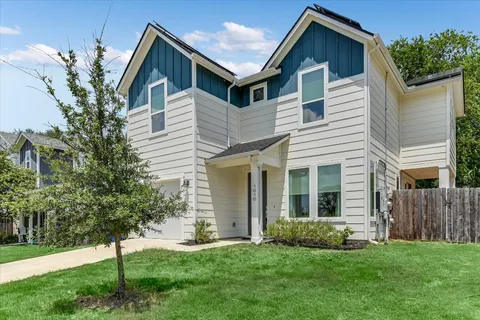 a front view of a house with a yard and green space