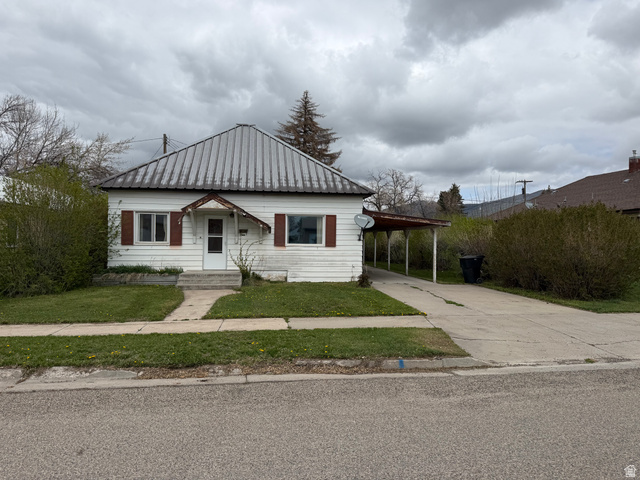 536 Jefferson Street Montpelier, ID 83254 - Photo 1 of 1 View of front of house featuring an attached carport, a metal roof, driveway, and a front lawn