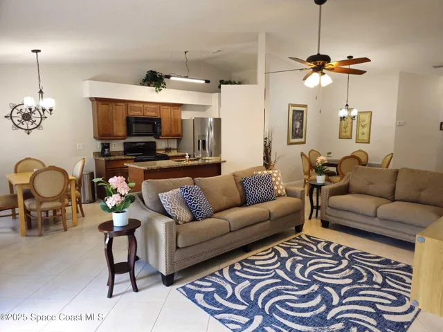 a living room with furniture a flat screen tv and a chandelier