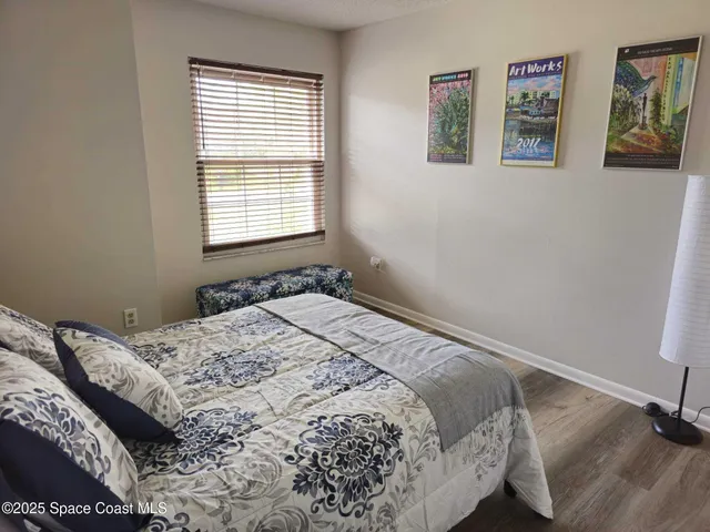 a bed sitting in a bedroom next to a window