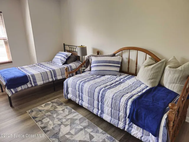 a bedroom with two beds and a window