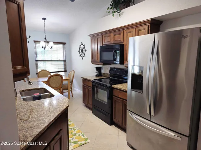 a kitchen with granite countertop a refrigerator and a stove