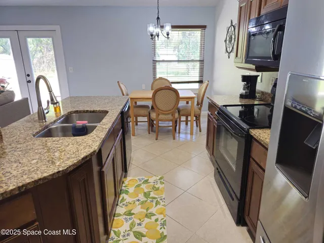 a kitchen with granite countertop a sink a stove and a microwave