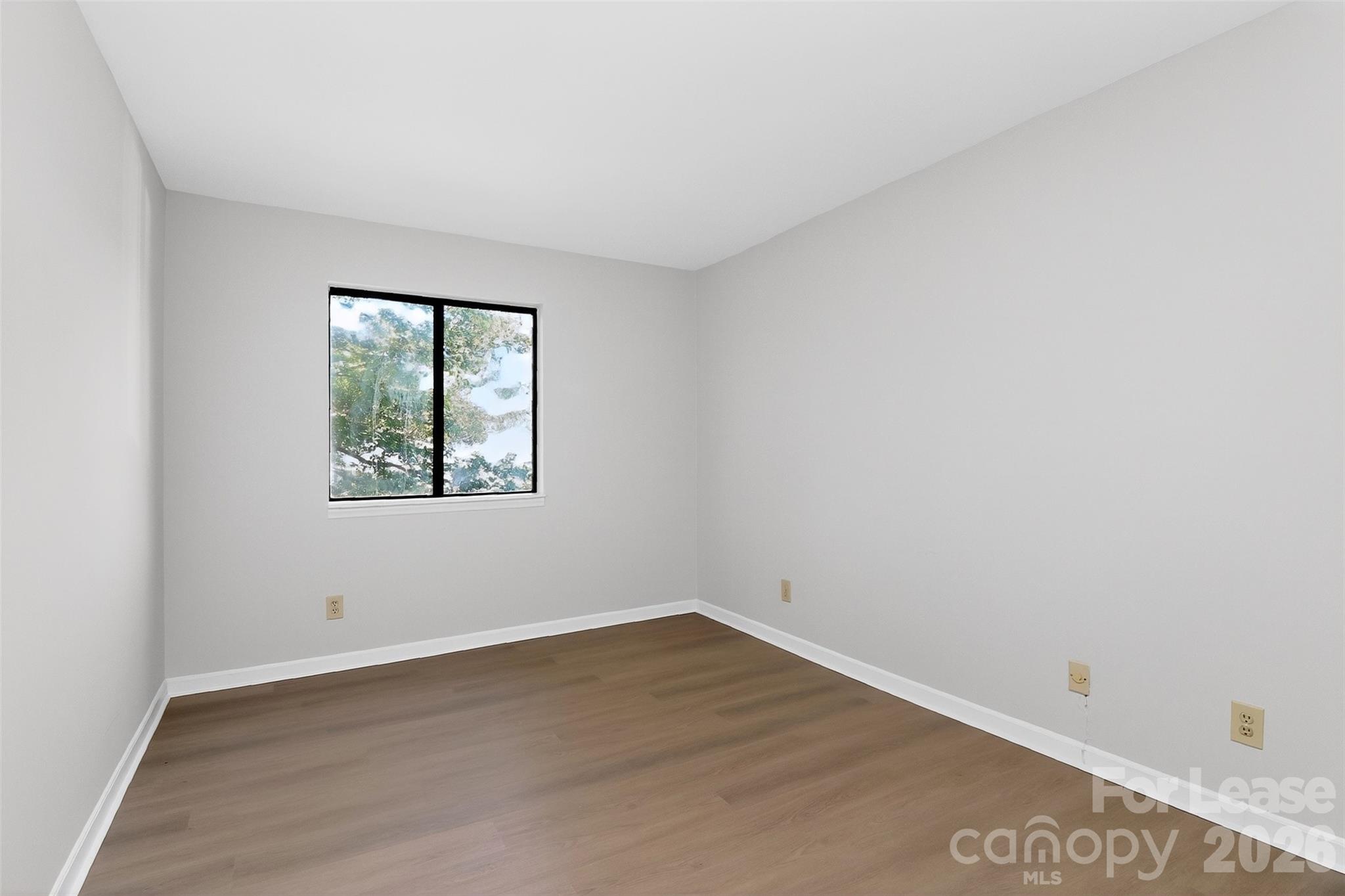 11029 Harrowfield Road Charlotte, NC 28226 - Photo 24 of 41 an empty room with wooden floor and windows