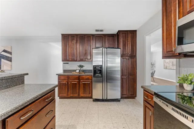a kitchen with stainless steel appliances granite countertop a refrigerator and a stove