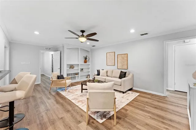 a living room with furniture and a wooden floor