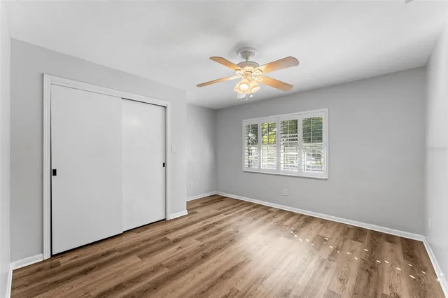 a view of an empty room with a window and wooden floor