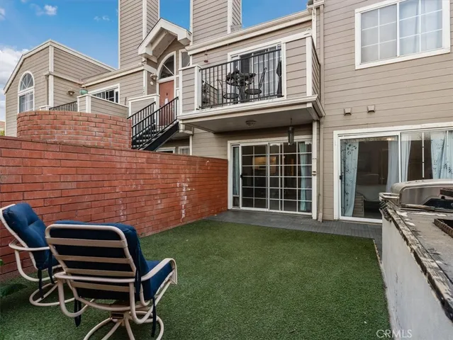 a backyard of a house with barbeque oven and glass windows