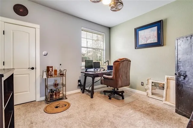 a view of a workspace with furniture and a window