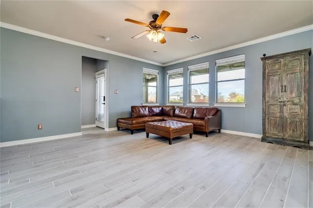 a living room with furniture and a ceiling fan