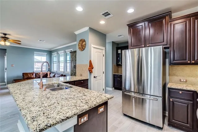 a kitchen with stainless steel appliances granite countertop a refrigerator oven a sink and dishwasher