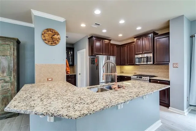 a kitchen with kitchen island granite countertop wooden cabinets and a refrigerator