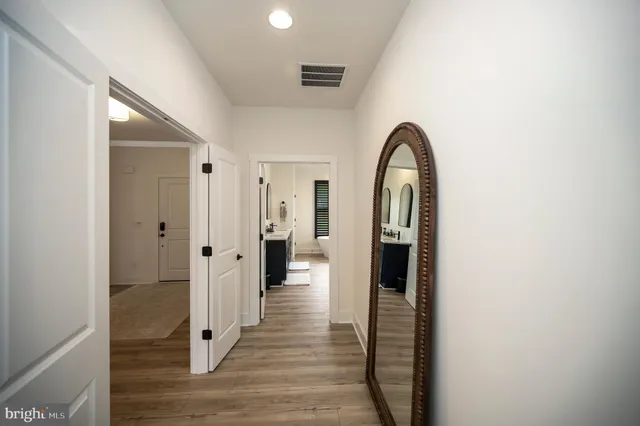 a view of a hallway with wooden floor and staircase