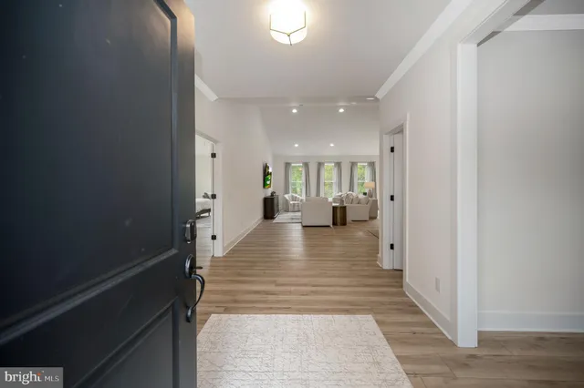 a view of a hallway with the wooden floor and a living room