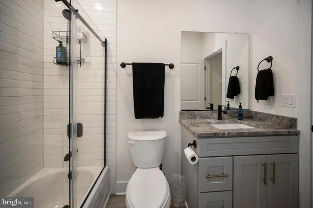 a bathroom with a granite countertop sink toilet and shower