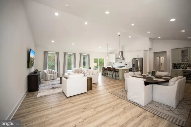 a living room with furniture a wooden floor and a flat screen tv