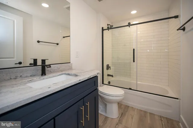a bathroom with a granite countertop sink toilet and shower