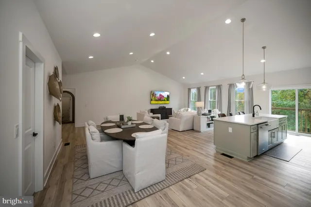 a kitchen with stainless steel appliances granite countertop a sink dishwasher a stove and a refrigerator with wooden floor