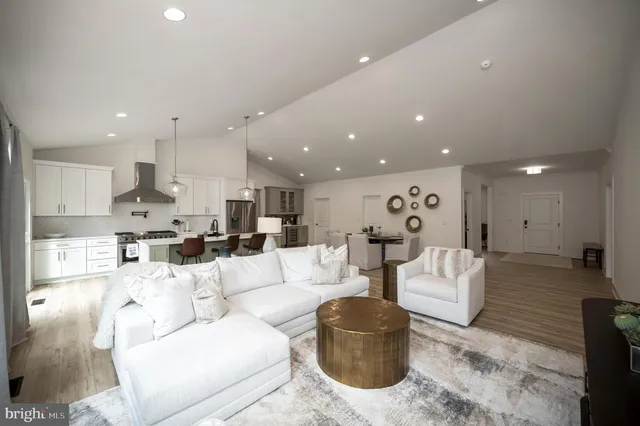 a living room with furniture white walls and kitchen view