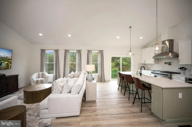 a living room with furniture wooden floor and a large window