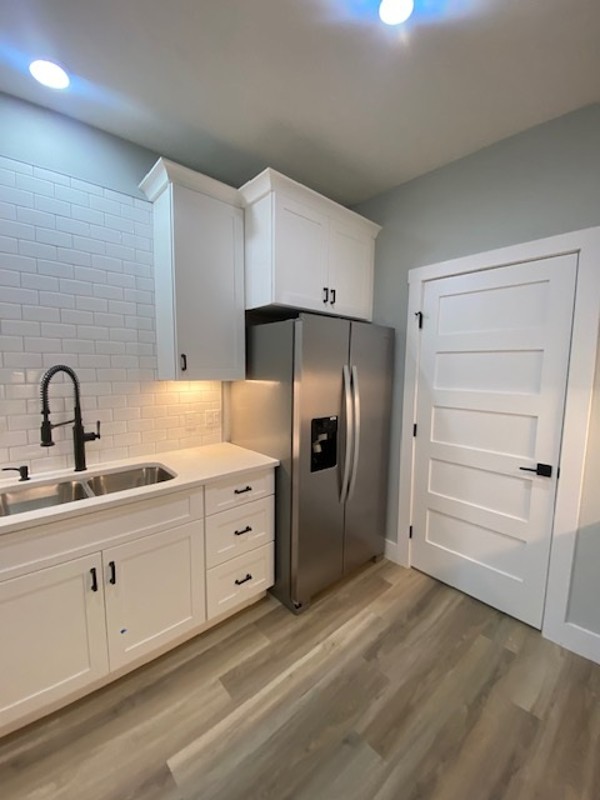 116 Field Street Luling, TX 78648 - Photo 5 of 33 A sleek kitchen features modern white cabinetry, stainless steel appliances, and durable flooring.