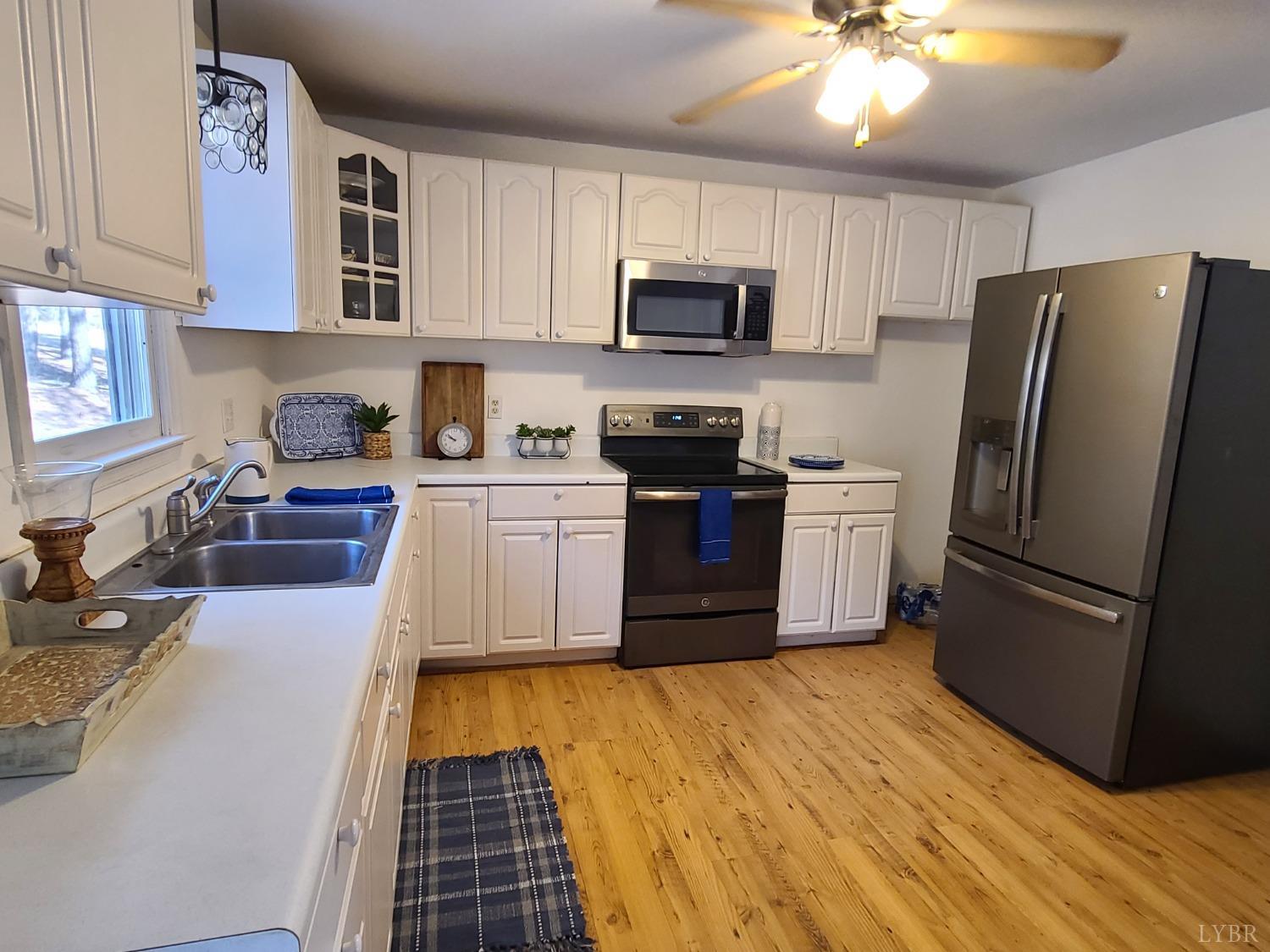 1641 Roark Mill Road Hurt, VA 24563 - Photo 6 of 52 a kitchen with stainless steel appliances granite countertop a stove top oven a sink dishwasher a refrigerator and cabinets with wooden floor