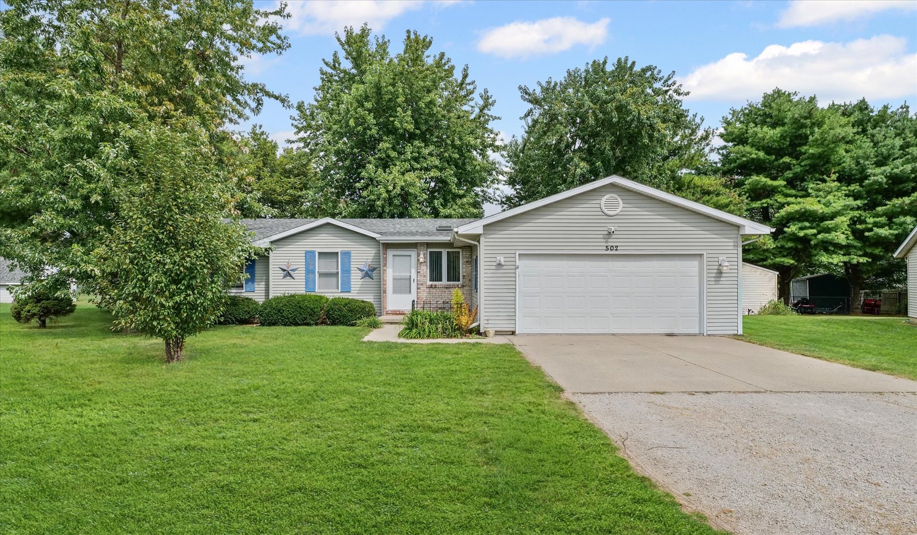 a front view of house with a yard and trees