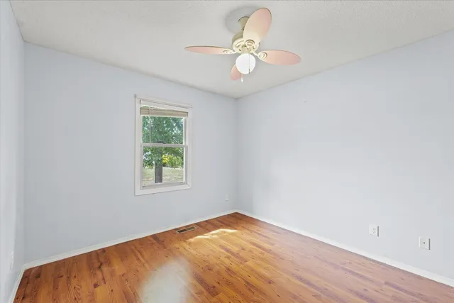 a view of a livingroom with a ceiling fan wooden floor and a chandelier fan