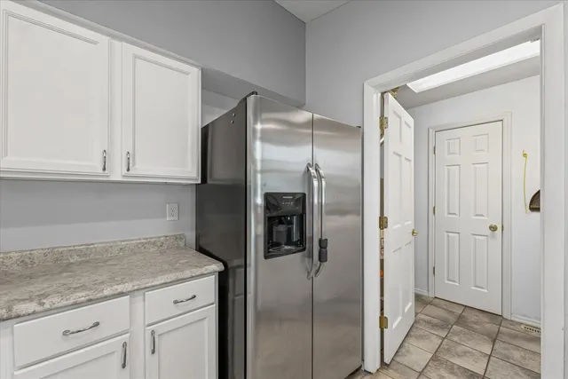 a kitchen with granite countertop a sink window and cabinets