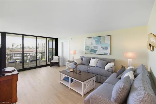 a living room with furniture large windows and a flat screen tv