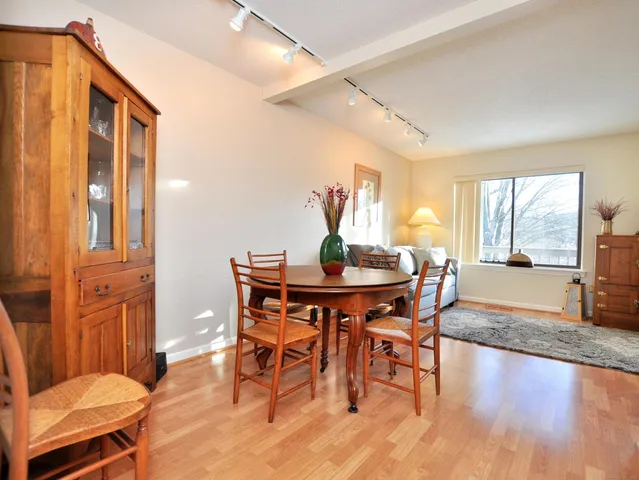 a dining room with furniture a chandelier and wooden floor